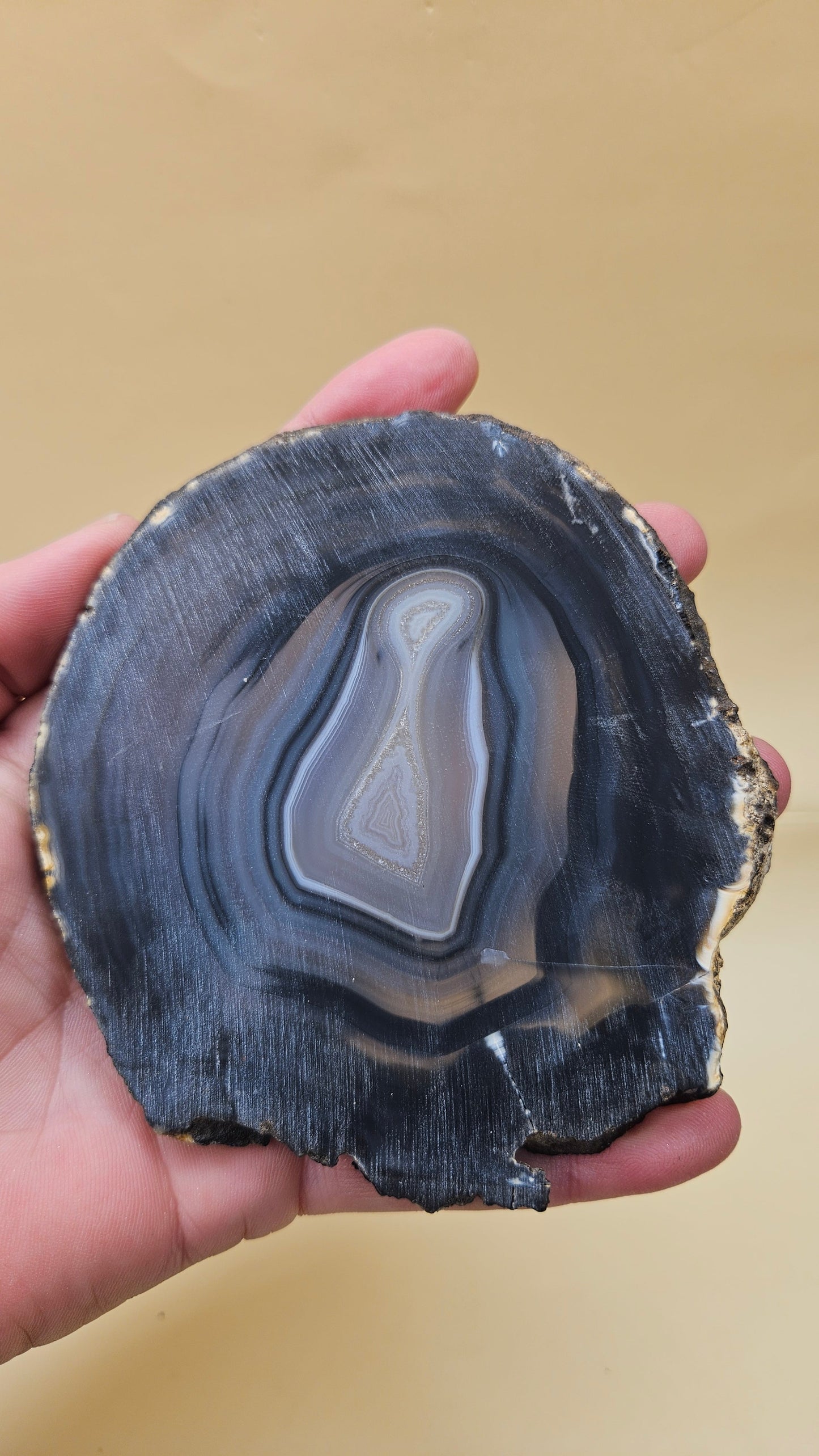 Brazilian Agate slab with dark bullseye pattern, black and gray concentric bands, and a quartz crystal center, 140 grams.