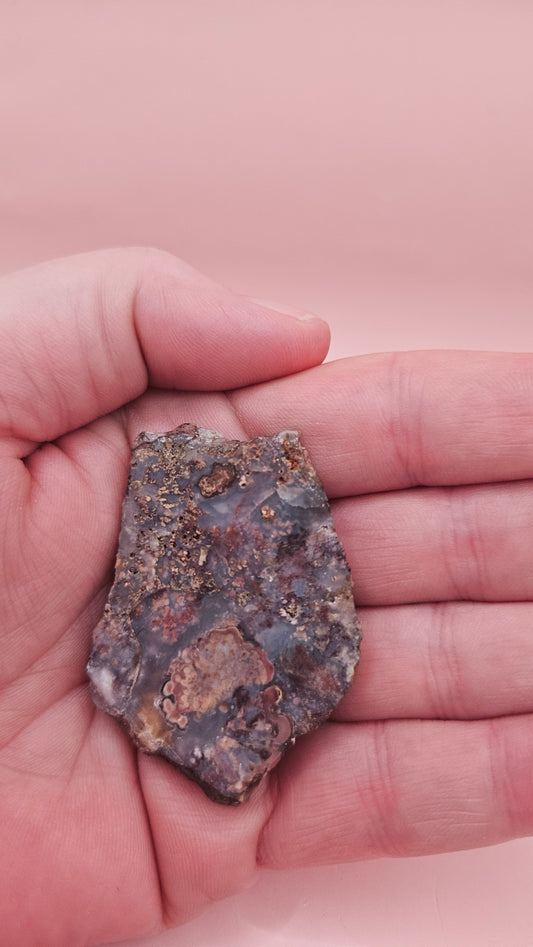18g Moss Agate slab featuring lavender, gold, and reddish inclusions with rough edges, 2.1x1.4 inches, shown in hand.