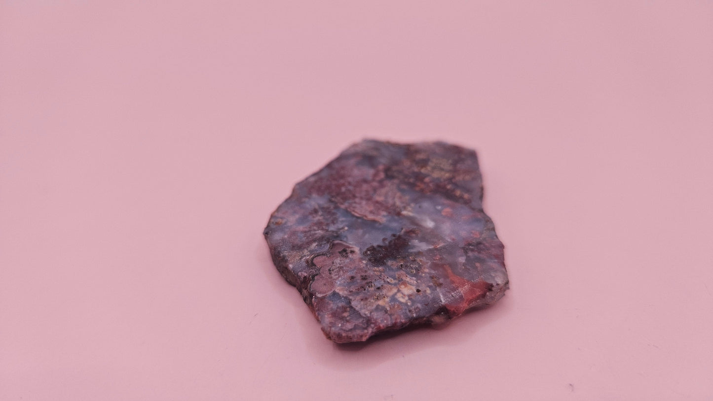 18g Moss Agate slab featuring lavender, gold, and reddish inclusions with rough edges, 2.1x1.4 inches, shown in hand.
