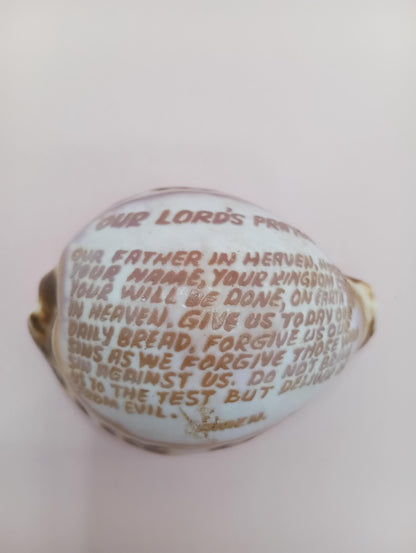 Single carved Lord’s Prayer cowrie shell, white background
