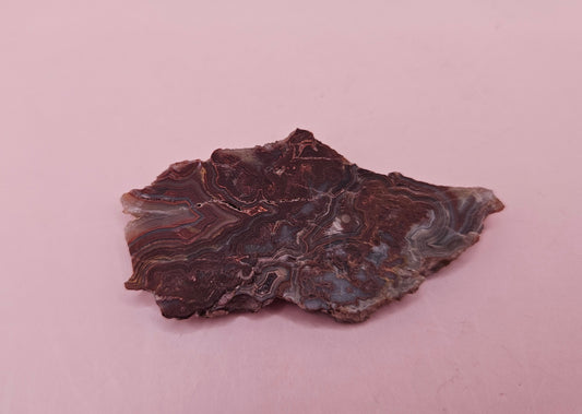 Polished Crazy Lace Agate slab featuring vivid red, gray, tan, and cream swirls with bold banded patterns, 21 grams from Mexico.