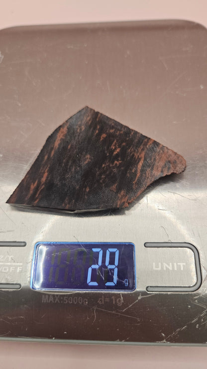 Polished Mahogany Obsidian slab with reddish-brown and black bands, weighing 29 grams, shown against a pink background.