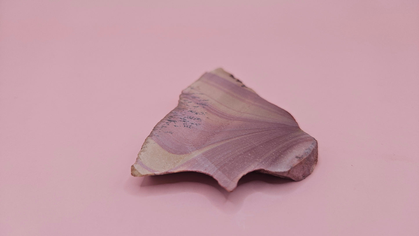 Close-up of Hatch, NM rhyolite slab showing mauve and tan swirled banding with black dendritic inclusions – 26g, cut for display or lapidary.