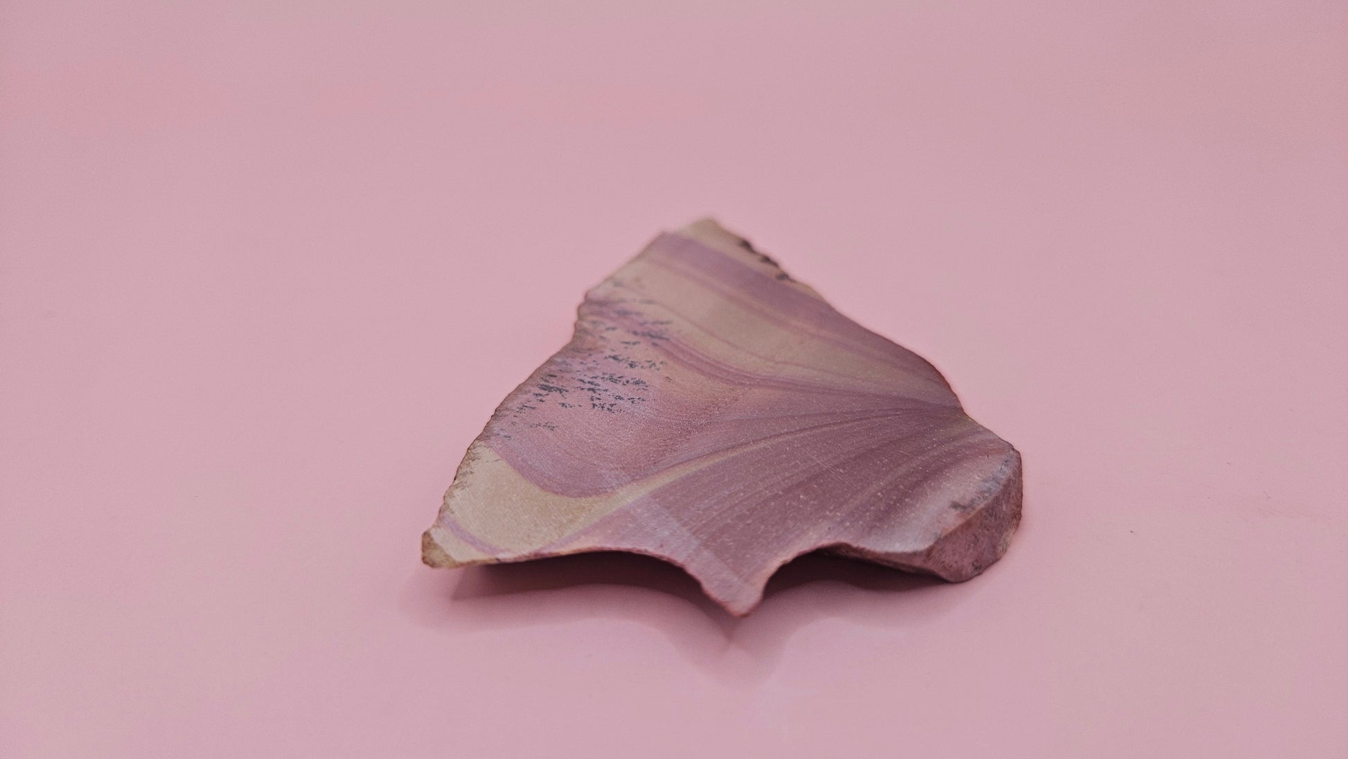 Close-up of Hatch, NM rhyolite slab showing mauve and tan swirled banding with black dendritic inclusions – 26g, cut for display or lapidary.