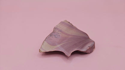 Close-up of Hatch, NM rhyolite slab showing mauve and tan swirled banding with black dendritic inclusions – 26g, cut for display or lapidary.