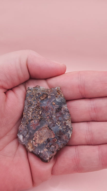18g Moss Agate slab featuring lavender, gold, and reddish inclusions with rough edges, 2.1x1.4 inches, shown in hand.