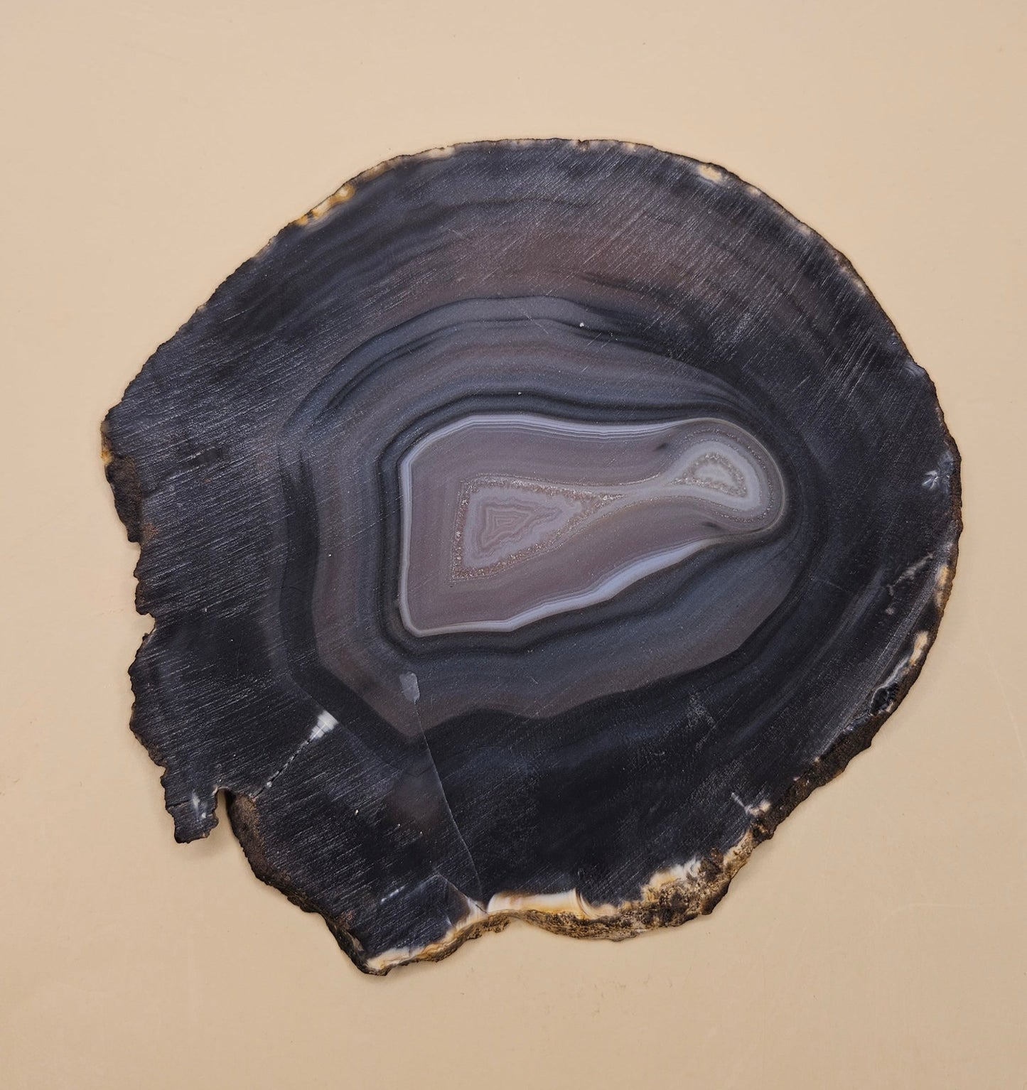 Brazilian Agate slab with dark bullseye pattern, black and gray concentric bands, and a quartz crystal center, 140 grams.