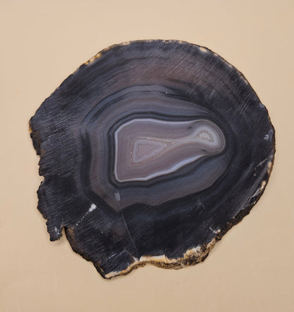 Brazilian Agate slab with dark bullseye pattern, black and gray concentric bands, and a quartz crystal center, 140 grams.