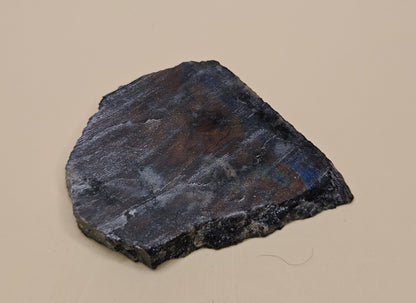 Red Spectrolite slab from Finland  showing red and blue flash over dark feldspar base, 36 grams.