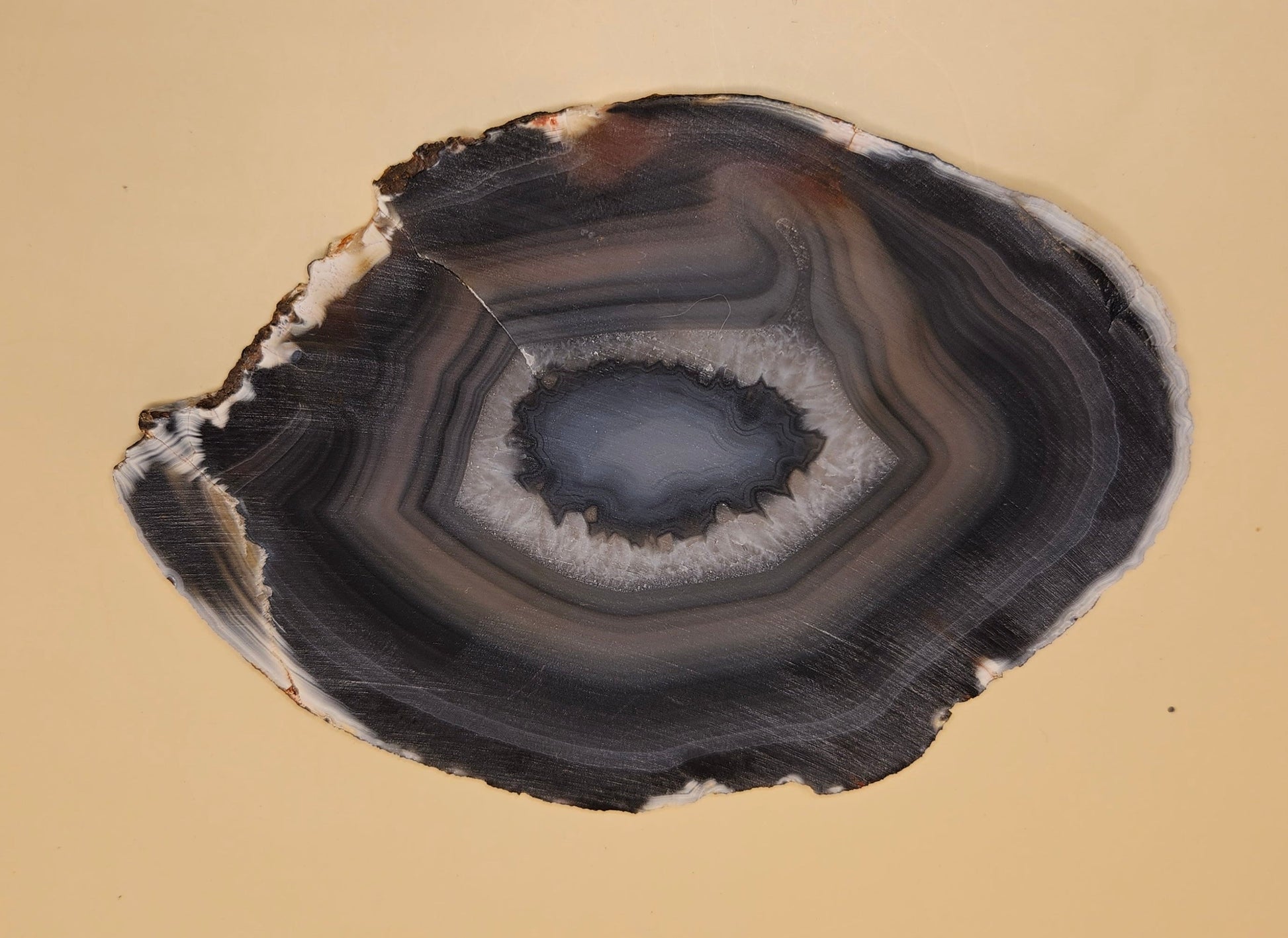 Brazilian Agate slab with dark bullseye pattern, black and gray concentric bands, and a quartz crystal center, 140 grams.