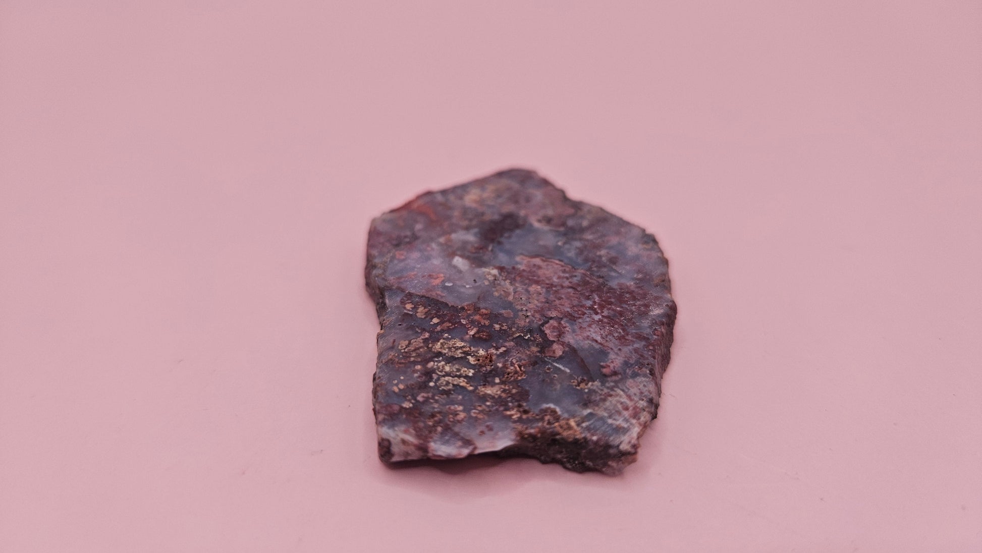 18g Moss Agate slab featuring lavender, gold, and reddish inclusions with rough edges, 2.1x1.4 inches, shown in hand.