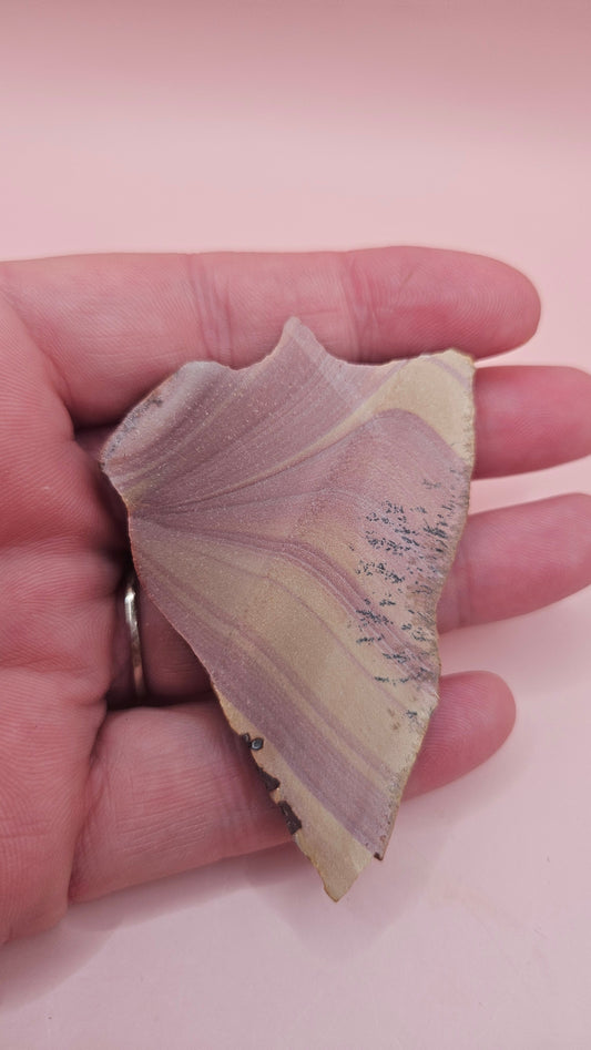 Close-up of Hatch, NM rhyolite slab showing mauve and tan swirled banding with black dendritic inclusions – 26g, cut for display or lapidary.