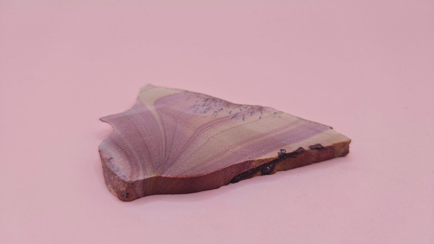 Close-up of Hatch, NM rhyolite slab showing mauve and tan swirled banding with black dendritic inclusions – 26g, cut for display or lapidary.